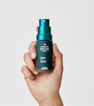 3. endocare_firming-serum_packshot_grey-background_in-hand_2026